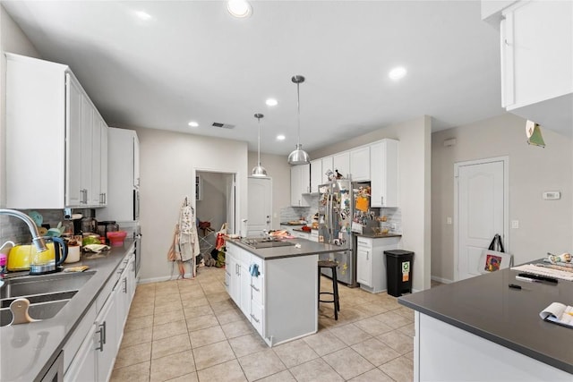 5357 Austral Loop, Austin, TX 78739 - kitchen with dark countertops, stainless steel fridge with ice dispenser, a kitchen island, tasteful backsplash, and recessed lighting