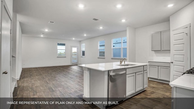 549 Osprey Dr, Leander, TX 78641 - kitchen featuring stainless steel dishwasher, a sink, a center island with sink, dark wood finished floors, and light countertops