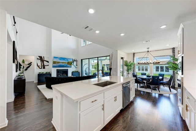 5028 Olimpico Way, Leander, TX 78641 - kitchen with a glass covered fireplace, appliances with stainless steel finishes, dark wood-style floors, light countertops, and recessed lighting