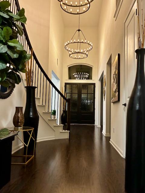 5028 Olimpico Way, Leander, TX 78641 - entrance foyer with a chandelier, a towering ceiling, stairs, baseboards, and wood finished floors
