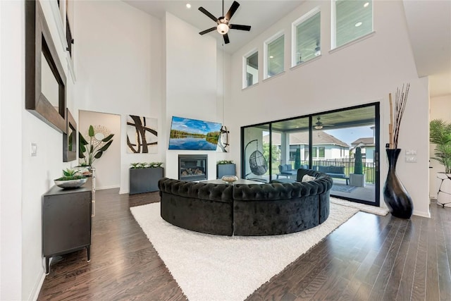 5028 Olimpico Way, Leander, TX 78641 - living room with a high ceiling, a glass covered fireplace, dark wood-style floors, a ceiling fan, and recessed lighting