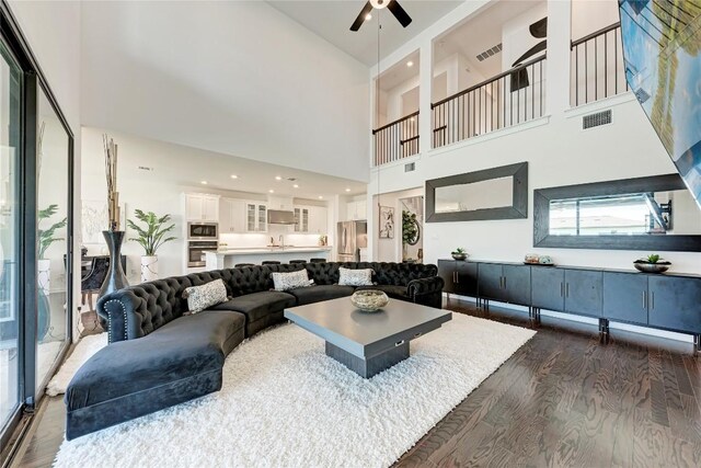 5028 Olimpico Way, Leander, TX 78641 - living room featuring dark wood-style floors, a ceiling fan, and a towering ceiling