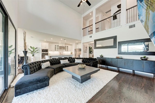 5028 Olimpico Way, Leander, TX 78641 - living area with dark wood-style floors, ceiling fan, and a towering ceiling