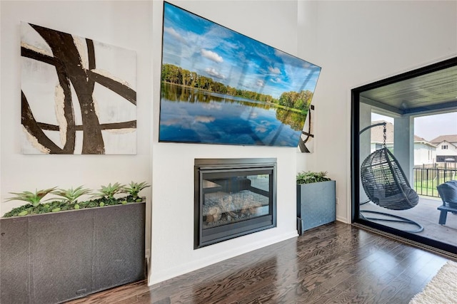 5028 Olimpico Way, Leander, TX 78641 - unfurnished living room featuring wood finished floors, baseboards, and a glass covered fireplace