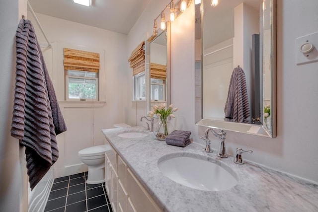 2010 Alguno Rd, Austin, TX 78757 - full bath featuring toilet, double vanity, and tile patterned flooring