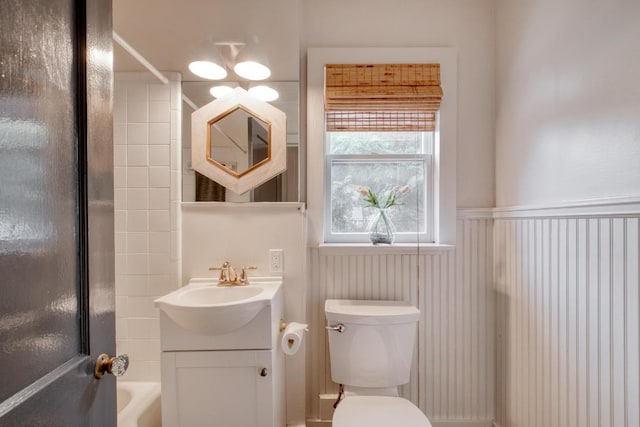 2010 Alguno Rd, Austin, TX 78757 - bathroom featuring vanity, washtub / shower combination, toilet, and a wainscoted wall