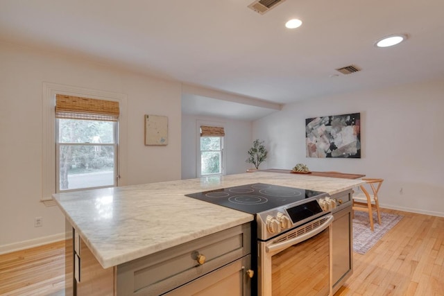 2010 Alguno Rd, Austin, TX 78757 - kitchen with electric range, light wood-style floors, recessed lighting, a kitchen island, and baseboards