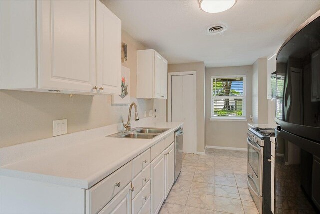8711 Bridgeport Dr, Austin, TX 78758 - kitchen with stainless steel appliances, white cabinets, light countertops, and light marble finish flooring