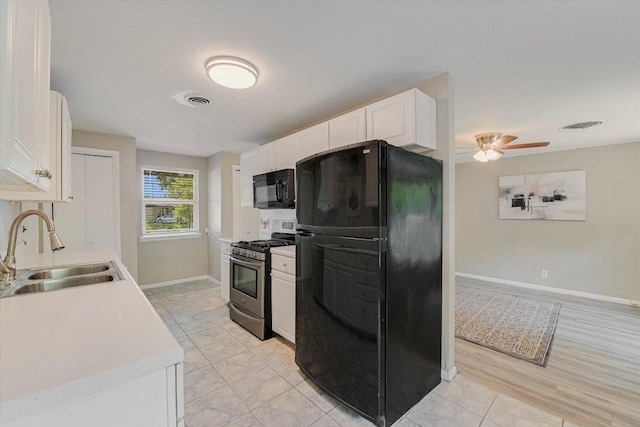8711 Bridgeport Dr, Austin, TX 78758 - kitchen with black appliances, a sink, white cabinetry, baseboards, and light countertops