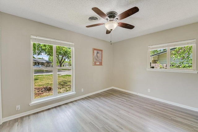 8711 Bridgeport Dr, Austin, TX 78758 - unfurnished room featuring plenty of natural light, wood finished floors, a ceiling fan, baseboards, and a textured ceiling