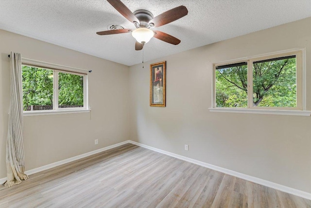 8711 Bridgeport Dr, Austin, TX 78758 - empty room featuring wood finished floors, healthy amount of natural light, a textured ceiling, and baseboards