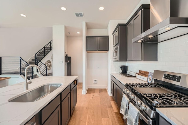 1531 N Red Bud Ln Unit 34, Round Rock, TX 78665 - kitchen featuring stainless steel appliances, wall chimney range hood, light stone countertops, recessed lighting, and light wood finished floors