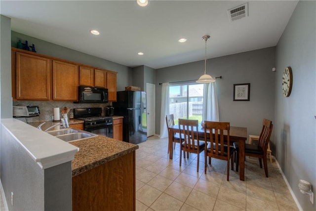 564 Moonwalker Trl, Buda, TX 78610 - kitchen featuring black appliances, brown cabinetry, tasteful backsplash, a sink, and baseboards