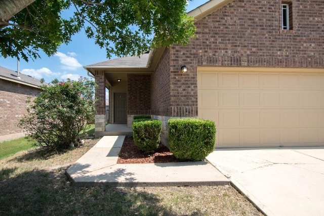 564 Moonwalker Trl, Buda, TX 78610 - property entrance with brick siding, a garage, and concrete driveway