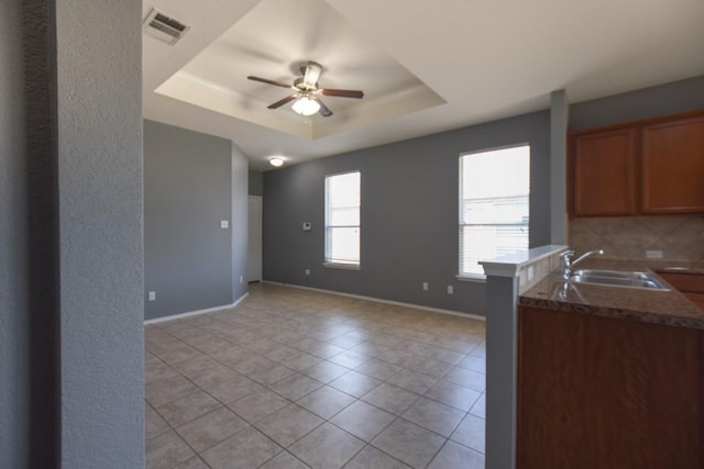 564 Moonwalker Trl, Buda, TX 78610 - kitchen with a sink, a tray ceiling, ceiling fan, and light tile patterned floors
