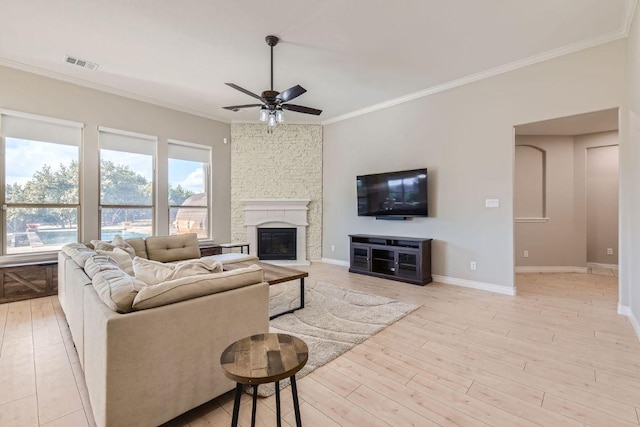 21808 Esmeralda Dr, Spicewood, TX 78669 - living room with ceiling fan, crown molding, a fireplace, baseboards, and light wood-style flooring