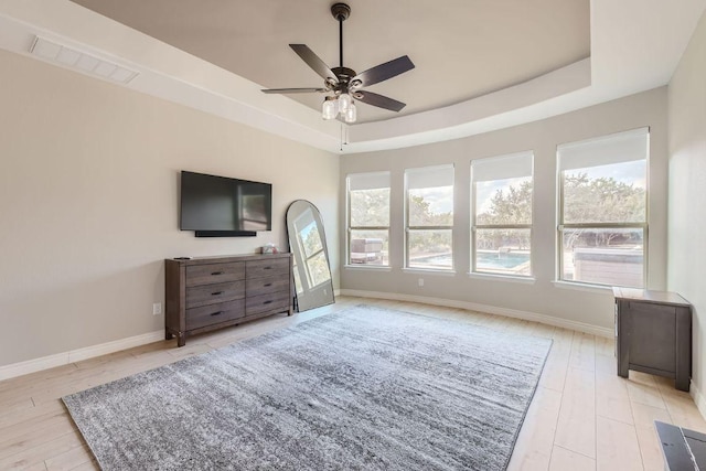 21808 Esmeralda Dr, Spicewood, TX 78669 - bedroom featuring a raised ceiling, multiple windows, and baseboards