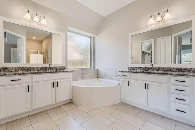 21808 Esmeralda Dr, Spicewood, TX 78669 - bathroom with a stall shower, two vanities, a bath, and vaulted ceiling