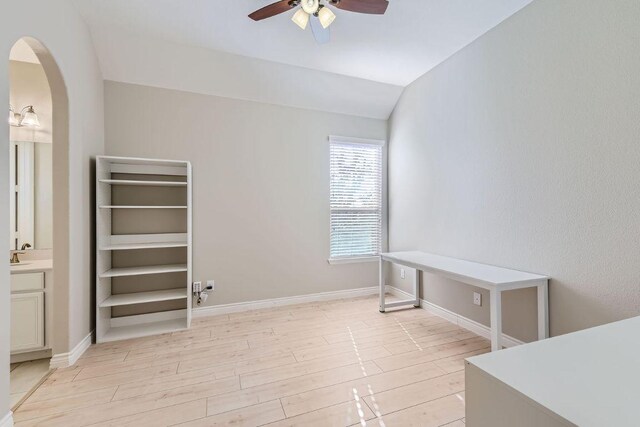 21808 Esmeralda Dr, Spicewood, TX 78669 - empty room with ceiling fan, arched walkways, light wood-style floors, baseboards, and lofted ceiling