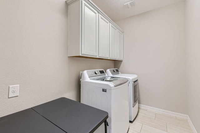 21808 Esmeralda Dr, Spicewood, TX 78669 - laundry area featuring washing machine and clothes dryer, cabinet space, and baseboards