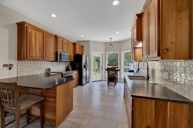 3055 Lakeview Dr, Canyon Lake, TX 78133 - kitchen featuring appliances with stainless steel finishes, a sink, brown cabinetry, dark countertops, and tasteful backsplash