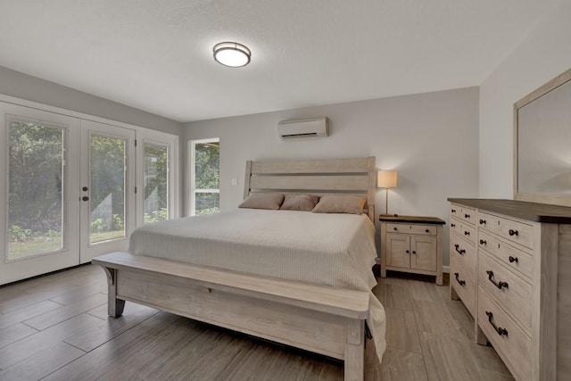 3055 Lakeview Dr, Canyon Lake, TX 78133 - bedroom with a wall mounted AC, light wood-style flooring, french doors, and access to exterior