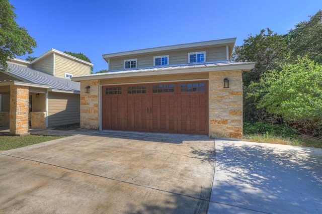 3055 Lakeview Dr, Canyon Lake, TX 78133 - view of front facade with stone siding, concrete driveway, metal roof, and a garage