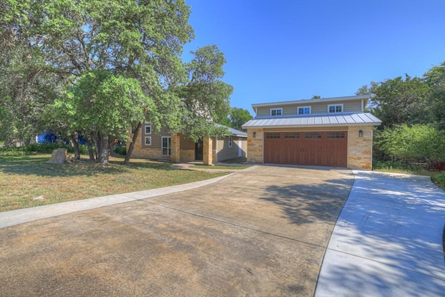 3055 Lakeview Dr, Canyon Lake, TX 78133 - view of front of house featuring concrete driveway, a garage, metal roof, a front lawn, and stone siding
