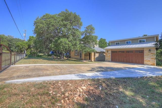 3055 Lakeview Dr, Canyon Lake, TX 78133 - view of front of property with concrete driveway, a garage, stone siding, and metal roof