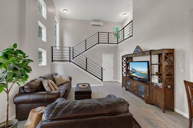 3055 Lakeview Dr, Canyon Lake, TX 78133 - living area with light wood-type flooring, baseboards, stairway, a high ceiling, and a wall mounted AC