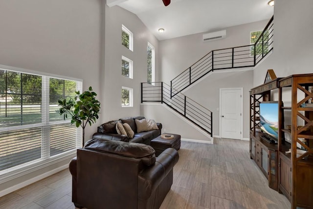3055 Lakeview Dr, Canyon Lake, TX 78133 - living area with high vaulted ceiling, healthy amount of natural light, stairs, a wall mounted air conditioner, and baseboards
