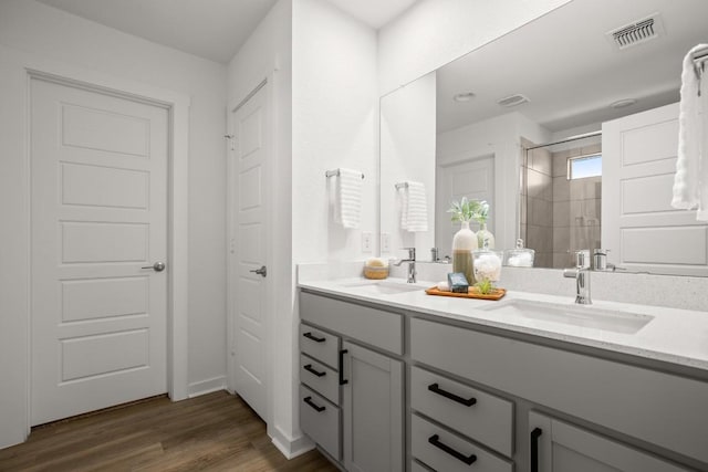 10208 Criswell Rd, Austin, TX 78754 - bathroom with double vanity, a stall shower, and wood finished floors