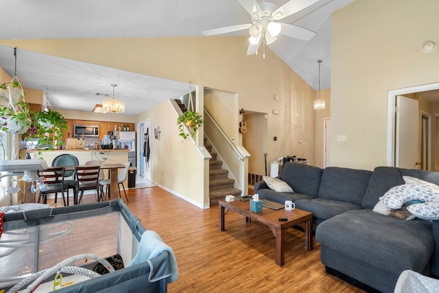2656 Piping Rock Trl, Austin, TX 78748 - living room featuring a chandelier, light wood-type flooring, a ceiling fan, high vaulted ceiling, and stairway