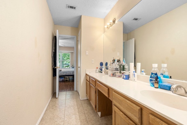 2656 Piping Rock Trl, Austin, TX 78748 - ensuite bathroom with vanity, tile patterned flooring, a textured ceiling, and baseboards