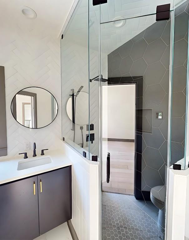 2700 Marina Shores Dr, Spicewood, TX 78669 - bathroom featuring tile walls, vanity, a shower stall, and toilet