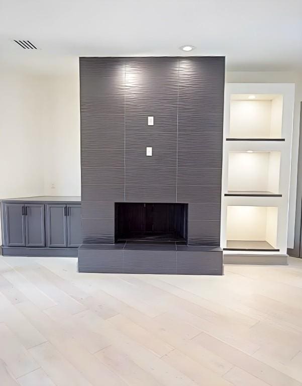 2700 Marina Shores Dr, Spicewood, TX 78669 - unfurnished living room with a large fireplace, light wood finished floors, and recessed lighting
