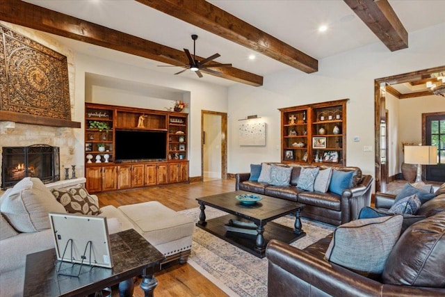 535 Creekside Dr, Salado, TX 76571 - living area featuring wood finished floors, a ceiling fan, baseboards, a stone fireplace, and beam ceiling