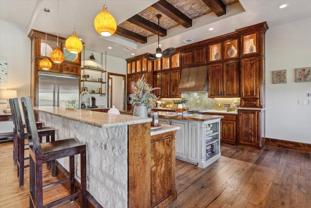 535 Creekside Dr, Salado, TX 76571 - kitchen with an island with sink, custom exhaust hood, stainless steel built in fridge, open shelves, and beam ceiling