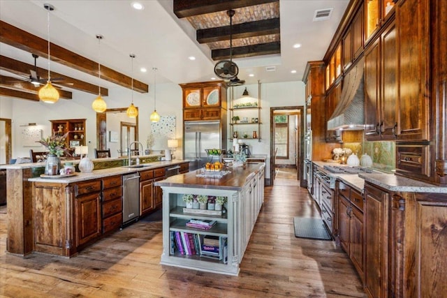 535 Creekside Dr, Salado, TX 76571 - kitchen with open shelves, built in fridge, beamed ceiling, an island with sink, and a sink