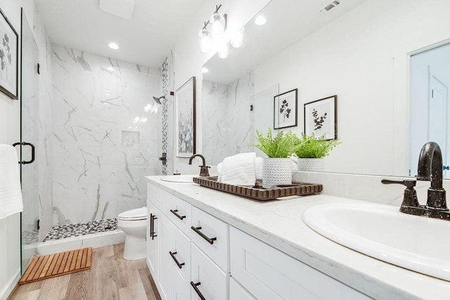 148 Feather Way, Fredericksburg, TX 78624 - full bath with a marble finish shower, toilet, double vanity, wood finished floors, and recessed lighting