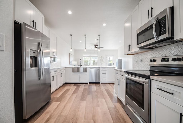 148 Feather Way, Fredericksburg, TX 78624 - kitchen featuring stainless steel appliances, a sink, a ceiling fan, light wood-type flooring, and white cabinetry