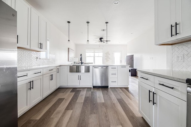 148 Feather Way, Fredericksburg, TX 78624 - kitchen featuring appliances with stainless steel finishes, a sink, a peninsula, ceiling fan, and light wood-style floors