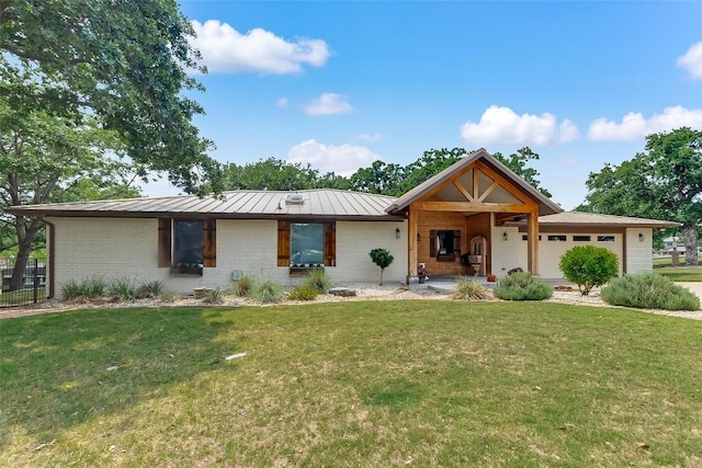 408 Sombrero, Horseshoe Bay, TX 78657 - view of front facade featuring a standing seam roof, an attached garage, brick siding, and a metal roof