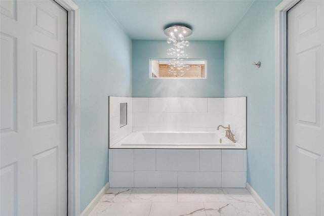 408 Sombrero, Horseshoe Bay, TX 78657 - full bathroom with marble look tile flooring, a garden tub, and a chandelier