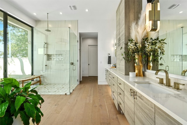 8209 Two Coves Dr, Austin, TX 78730 - full bath featuring a stall shower, double vanity, hardwood / wood-style flooring, and recessed lighting