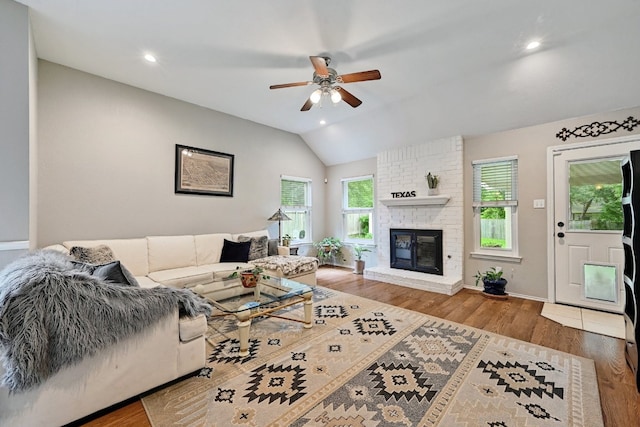 10603 Watchful Fox Dr, Austin, TX 78748 - living room with ceiling fan, wood finished floors, lofted ceiling, a brick fireplace, and baseboards