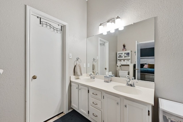 10603 Watchful Fox Dr, Austin, TX 78748 - bathroom with toilet, double vanity, and a textured wall