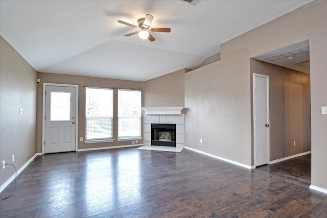 102 Cavalry Trl, Elgin, TX 78621 - unfurnished living room featuring ceiling fan, a tile fireplace, wood finished floors, baseboards, and vaulted ceiling