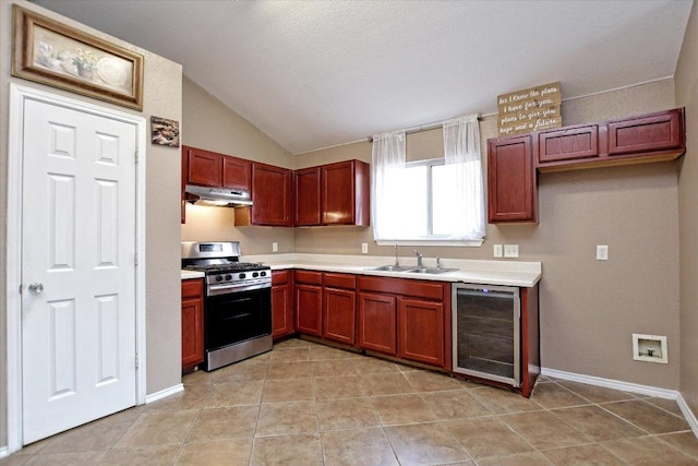 102 Cavalry Trl, Elgin, TX 78621 - kitchen featuring gas stove, wine cooler, under cabinet range hood, lofted ceiling, and light countertops