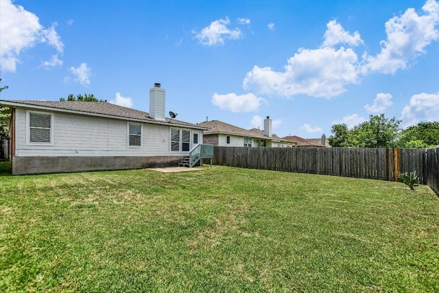 102 Cavalry Trl, Elgin, TX 78621 - back of property featuring a fenced backyard and a chimney